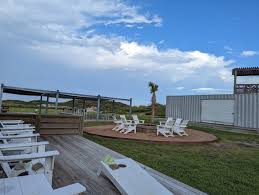 🌴☀️ Your Perfect Coastal Hangout Spot Awaits! 🏖️ Whether you're soaking  in the sun or enjoying a cozy evening by the fire pit, this relaxing corner  at Lively Beach is all about