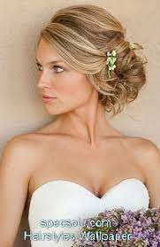 Revishing Heart Shaped Face Woman With Bun And Flowers Accessories On Layered Medium Golden Blonde Diy Wedding Hai Wedding Hair Side Hair Styles Long Hair Updo