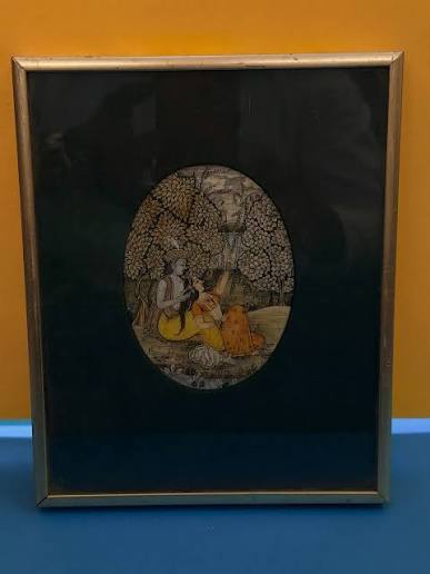 A Rajasthani or Pahari miniature painting — likely Krishna and Radha in a garden. Oval composition, gold leaf trees, hand-painted on paper or old manuscript. Style looks like 19th–early 20th century. #IndianMiniaturePainting #