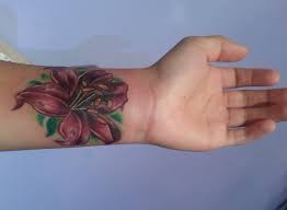 Flowers are one of the most beautiful things created by god and usually treated as a symbol of femininity. Latest Lily Flower Tattoo On Left Wrist
