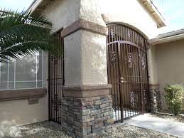 Cable railings from loftus iron add to the contemporary style of the home, including a gate feature at the top of the front steps to contain the family pets when they're let out into the yard. Wrought Iron Entry Gate With Porch Enclosure Panels Door Gate Design Wrought Iron Fences Wrought Iron Gate Designs