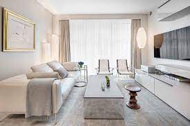 The dark wood floor and the white walls make for an amazing color combination and the floor to ceiling french style doors leading to the green courtyard outside offer a beautiful contrast to the overall design while letting light flood the living room. 8 Luxurious Living Room Interior Design Ideas For Inspiration Decor Aid
