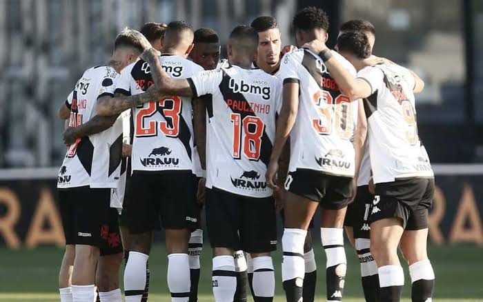 Torcida vibrando nas arquibancadas de um estádio de futebol iluminado