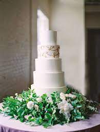 Nestled In A Bed Of Flowers And Foliage How Could This Five Tiered Cake Aholics Bakery Confect Romantic Wedding Cake Cool Wedding Cakes Metallic Wedding Cakes