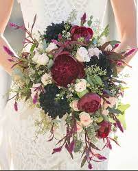 A moody wedding bouquet of orange and burgundy flowers, greenery and thistles plus some cascading touches. Pin By Sarah Gutierrez On Wedding Flowers Cascading Wedding Bouquets Fall Wedding Bouquets Wedding Flowers