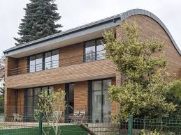 Une Maison Double Face A Toiture Cintree Et Grandes Baies Vitrees Toiture Maison Maison Ossature Bois