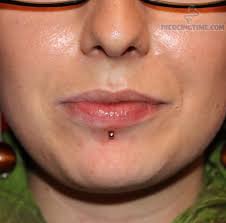 lower lip gold stud center labret piercing