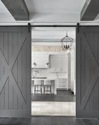 Black And White Barn Door Dual Gray Barn Doors On Rails Open To A Light Gray Kitchen Featuring Light Gray Leather Counter Stools Place White Barn Door Interior Barn Doors Wood Barn Door