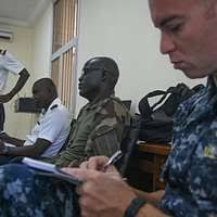 Capt. Eric Pfister, commanding officer of the amphibious assault ship USS  Bataan, greets Cdr. Ian Feasey, commanding officer of the Royal Navy  frigate HMS Monmouth, during a visit to Bataan during exercise