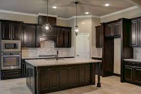 Accent colors include a deep brown range hood, black kitchen island, and deep grey marble countertops. 20 Best Dark Stained Cabinets Ideas Kitchen Remodel Kitchen Design Kitchen Renovation