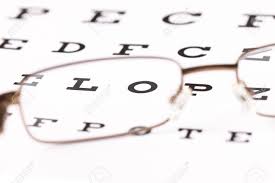 a pair of reading glasses sitting on a eye test chart with only