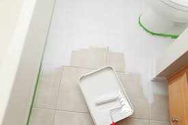 The kit comes with a deglosser designed to clean your cabinets and remove anything that might prevent paint from sticking. Taping Off Edges For Transformation Of Outdated Tile With Gray And White Rust Oleum Paint Painting Tile Floors Bathroom Tile Diy Painted Floors