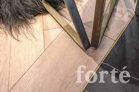 A Plank Border With Brass Trim Defines The Transition Between Timber Tile In 2021 Inlay Flooring Timber Tiles Flooring