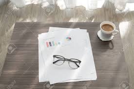 office table with modern glasses on business report chart paper