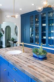 These beautiful kitchen islands by john boos will provide you with a large work surface and useful storage. Contemporary White Kitchen Featuring Blue Cabinets And Island With Butcher Block Top Hgtv