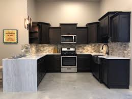 The overall classic look of the design is achieved with light quartz countertops and backsplashes. Charcoal Gray Wood Cabinetry Wholesale In Austin Texas