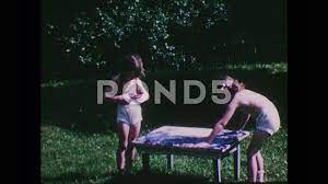 1940s: Two girls finger painting in yard... | Stock Video | Pond5