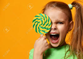 Happy Young Little Child Girl With Sweet Lollypop Candy Surprised Screaming  Yelling On Yellow Background Stock Photo, Picture and Royalty Free Image.  Image 95283798.