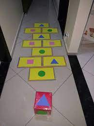 A criança joga o dado e segue a trilha pisando somente na figura sorteada. Amarelinha De Formas Artesanato Pre Escolar Formas Geometricas Educacao Infantil Brincadeiras Educacao Infantil