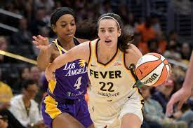 Indiana Fever guard Caitlin Clark (22) drives past Los Angeles Sparks guard  Lexie Brown (4) in the first half at Crypto.com Arena. | HoopsHype