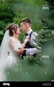 Hermosa pareja de recién casados caminando en el bosque. Recién Casados.  Novia y novio agarrando la mano en el bosque de pinos Fotografía de stock -  Alamy