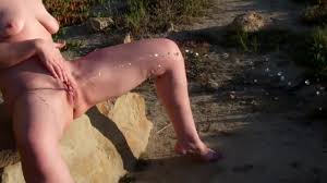 Sexy brunette pees on the public beach in San Diego