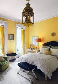 Stylish contemporary bedroom boasts a yellow and gray headboard fitted behind a bed dressed in yellow and gray bedding and placed on a beige rug. These 15 Color Trends Are Dominating 2018 Yellow Bedroom Decor Living Room Decor Yellow Walls Yellow Bedroom