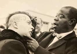 Louis Armstrong gives his autograph to a French punk, 1961.