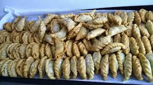 Empanadas chilenas tradicionales típicos con carne, cebolla, huevos y aceitunas en la tabla de cortar rústica mapuche en el fondo de madera azul. Rezept Fur Schnelle Leckere Empanadas America Andina