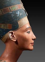A close-up of a small, painted Egyptian statue of a woman, likely Queen  Nefertiti, based