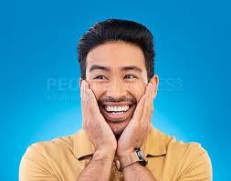 Happy, excited man and surprise face in studio with Asian model with teeth  and joy. Blue background, male person and casual fashion with handsome and  friendly guy with modern style and wow