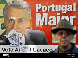 An elderly supporter of presidential candidate Anibal Cavaco Silva sits in  front of a bill board reading 'Vote Cavaco' and 'Greater Portugal'  promoting his candidate in the center of Lisbon, Friday, Jan.