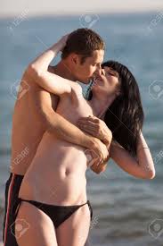 Attractive Couple At The Sea. Young Man Hids Naked Breasts Of His  Girlfriend And Kisses Her Stock Photo, Picture and Royalty Free Image.  Image 50417277.