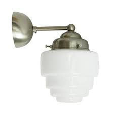 Three antique brass bar details accent the tapered clear organic seedy glass that forms the organic silhouette of this sconce. Wall Sconce With Art Deco Stepped Opal Glass Casa Lumi
