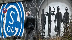 A man passes graffiti on wall with the logo of bundesliga soccer club fc schalke 04 and coal miners in the light at the end of the tunnel in gelsenkirchen, germany, monday, march 1, 2021. Xmppuuvwtimncm
