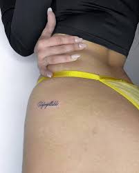 Tattoo of the word unforgettable done on the hip.