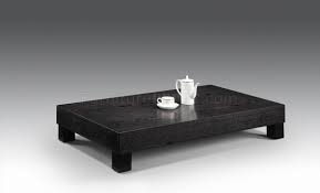 A coffee table is a low table designed to be placed in a sitting area for convenient support of beverages, remote controls, magazines, books (especially large, illustrated coffee table books), decorative objects, and other small items. Wenge Low Base Modern Coffee Table