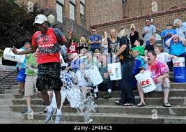 Pottsville Area High School Class of 1978 member Kirk Kirkland, Pottsville,  Pa., leaps after he was the last to have buckets of water dumped over his  head after classmates did the ALS