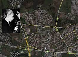 Luego, se los ve a ambos en el auto del comisario, quien le describe al protagonista de la serie: Ciudad Evita Seen From Above Gringo Starr