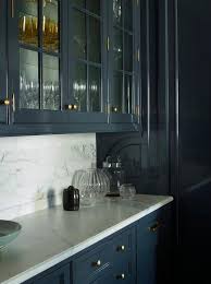 Dark Blue Lacquered Cabinets Adorned With Antique Brass Hardware And A White Marble Cou Dark Blue Kitchen Cabinets White Kitchen Decor White Marble Countertops