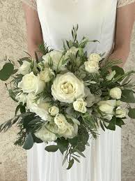 Flowers are as common in a wedding as a white dress. White Wedding Bouquet With Roses Lisianthus Rosemary Olive Leaf And Silver Eucalyptus Bridesmaid Bouquet White Wedding Bouquets White Bridal Bouquet