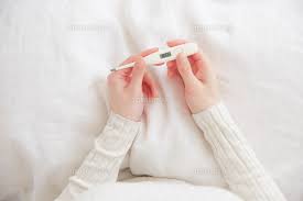 ベッドの上で体温計持つ女性の手元[10179013969]の写真素材・イラスト ...