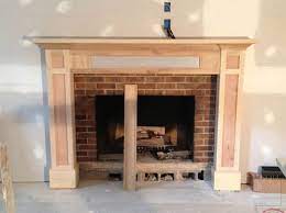 The warm brown and gold tones throughout the decor complement the exposed brick's natural color. Mantel With Storage Mitre Contracting Inc