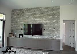 The white wall also accentuates the plant's vivid green color. Example Of A Modern Living Room Decorated With Gray Brick Tiles Mortonstones Brick T Accent Walls In Living Room Wall Tiles Living Room Brick Interior Wall