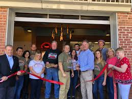 Mayor Robert Conley, joined by representatives from Tino's Artisan Pizza  Co., Borough Council, Downtown Development Commission and the Madison Area  Chamber of Commerce, cut the ribbon at the Grand Opening ribbon cutting