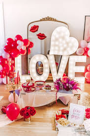 Themed valentine decorations like these table cloths drape the tables and the red plaid blanket draped over the chair adds warmth and texture. Glam Valentine S And Galentine S Party Decor Ideas Red Soles And Red Wine