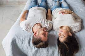 freepik young smiling couple lying on bed at home in casual outfit man and woman spending happy time together relaxing casual outfits romance free free photos
