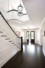 The Dark Wood Floors And Dark Wood Stairs And Railings Paired With The White Paint And Woodwork Is Beautifully Dramatic House Design New Homes House