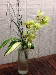 Unique Cymbidium Orchid In An Apothecary Bottle Trimmed With Curly Willow And Cymbidium Orchids Flower Arrangements Summer Flowers