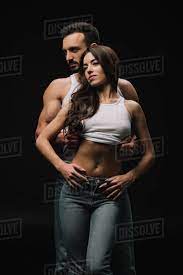 Im guessing there was one light used to the left of alya and maybe one from the front as we can see the shine on the chair. Handsome Man Undressing Woman In White Singlet Isolated On Black Stock Photo Dissolve